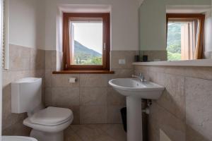 a bathroom with a toilet and a sink and a window at Locanda al Castello in Travesio +59 photos