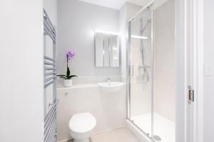 a bathroom with a shower and a toilet and a sink at Roomspace Serviced Apartments - Vertex House in Croydon