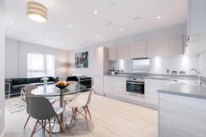 a kitchen and living room with a glass table and chairs at Roomspace Serviced Apartments - Vertex House in Croydon +13 photos