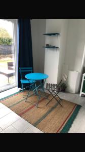 a blue table and chairs in a room with a window at La Casa di Manu in Lessona