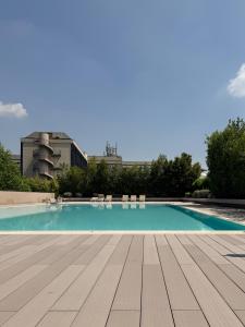 a swimming pool with chairs and a building in the background at ArtStay - Luxury Apt 1 Gym and Pool in Milan