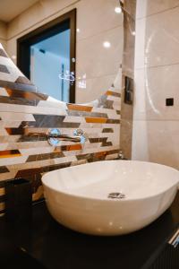 a bathroom with a white sink and a mirror at Apartament Patka Wysoki STANDARD in Grudziądz