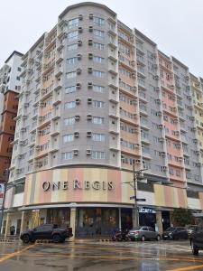 a large apartment building on a city street with cars at Studio 7C at One Regis in Bacolod