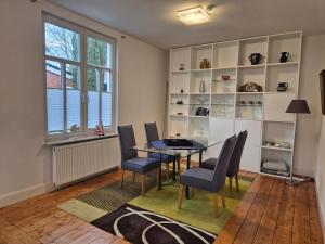 a dining room with a table and chairs and a window at Stadtvilla Norden in Norden