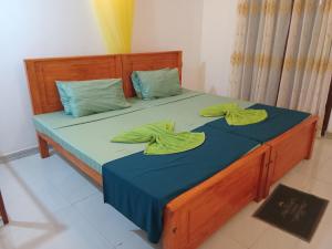 a bedroom with a bed with two green towels on it at River's Edge Resort Sinharaja in Kudawe +19 photos
