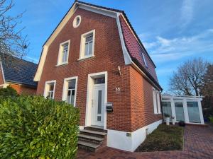 a red brick house with a white door at Stadtvilla Norden in Norden