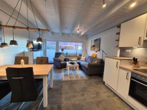 a kitchen and living room with a couch and a table at Zauberhaus in Norddeich