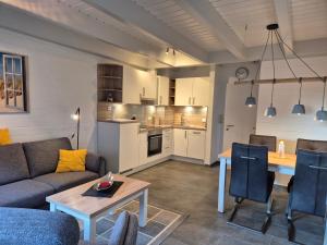 a living room with a couch and a table and a kitchen at Zauberhaus in Norddeich +16 photos