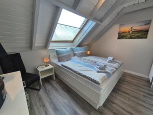 a large bed in a room with a window at Zauberhaus in Norddeich
