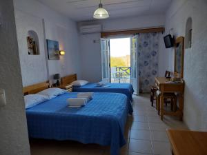 two beds in a room with blue sheets at ART STUDIO APARTMENTS in Órmos Aiyialís +8 photos