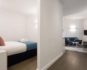 a bedroom with a bed and a living room at Abbott House by Viridian Apartments in St. Albans