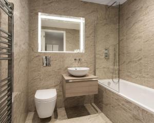 a bathroom with a sink and a toilet and a tub at Abbott House by Viridian Apartments in St. Albans +19 photos