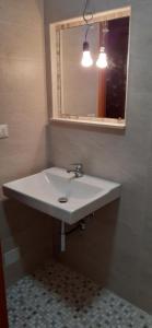 a bathroom with a white sink and a mirror at La Baita Baretana 2 in Barete