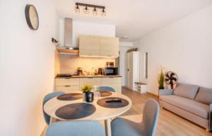 a kitchen and a living room with a table and chairs at Perła Bałtyku - kawalerka z dostępem do Resort &MediSpa in Sianozety