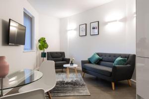 a living room with a couch and a table at Abbott House by Viridian Apartments in St. Albans
