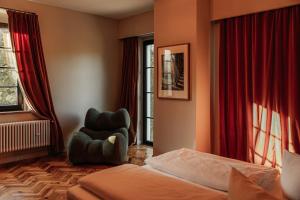 a hotel room with a bed and a chair at DAS SCHMÖCKWITZ in Berlin