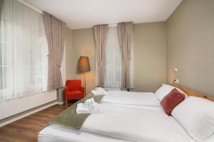 a hotel room with two beds and a red chair at BetweenLakes Apartment ground fl in Interlaken