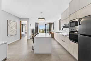 a kitchen with a white island in a room at Beachfront sea view apartment in Petite Case Noyale