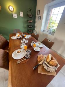 a wooden table with food and bread on it at Ferme les Chapelles Utah Beach in Angoville-au-Plain +9 photos