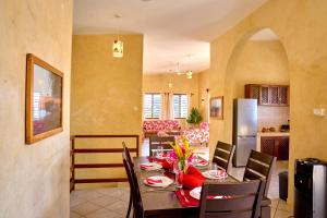 a kitchen and dining room with a table and chairs at Flametree Beach Homes in Diani Beach