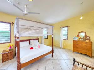 a bedroom with a bed and a dresser and a mirror at Flametree Beach Homes in Diani Beach +104 photos