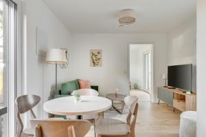a living room with a table and chairs and a tv at Haus Biederstaedt & LivJana in Ottersberg