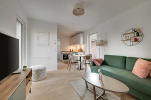 a living room with a green couch and a table at Haus Biederstaedt & LivJana in Ottersberg