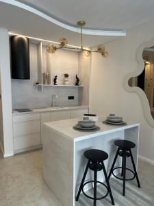a kitchen with two bar stools and a counter top at Mediteran Line Apartman 2 in Sombor