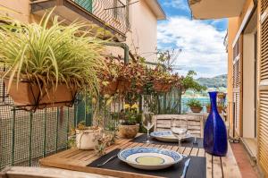 a table with plates and wine glasses on a balcony at CasaSolemare Terrace seaview AC in Portovenere