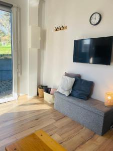 a living room with a couch and a flat screen tv at Les oiseaux de la Slack in Ambleteuse