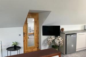 a living room with a table and a kitchen at Studio Sleeps 2 -Private Hot Tub -Enclosed Garden in Killarney