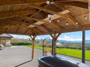 a wooden pergola with a swing on a patio at Studio Sleeps 2 -Private Hot Tub -Enclosed Garden in Killarney +6 photos