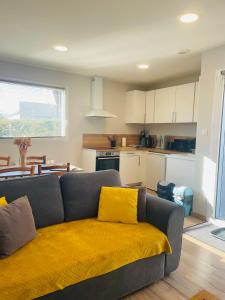 a living room with a couch with a yellow blanket at Les oiseaux de la Slack in Ambleteuse