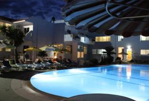 a large swimming pool in front of a building at night at Asterias Bay Hotel By Anayia All Inclusive Resorts in Theologos +12 photos
