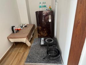 a small kitchen with a stove and a refrigerator at The leaf and Hill in Alwar +20 photos