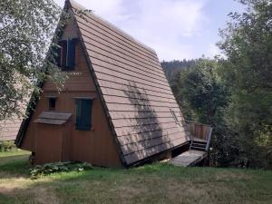 a small house with a porch and a staircase on it at Chalet du Lioran in Laveissière +3 photos