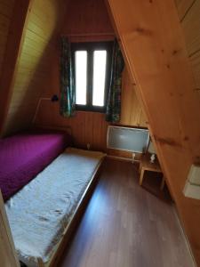 a small room with a bed and a window at Chalet du Lioran in Laveissière