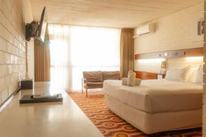 a hotel room with a large bed and a chair at Indian Ocean Hotel in Perth