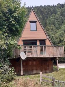 a house with a deck with a frisbee on it at Chalet du Lioran in Laveissière