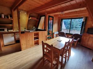 a kitchen and dining room with a table and chairs at Chalet du Lioran in Laveissière