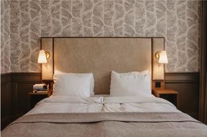 a bedroom with a large bed with two lamps at Home Hotel Amanda in Haugesund