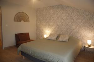 a bedroom with a bed and a chair at Appartement LE CHAI in Saint-Gaudens