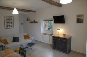 a living room with a white couch and a tv at Appartement LE CHAI in Saint-Gaudens