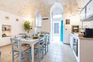 a kitchen and dining room with a table and chairs at Vico di Ostuni Stone Houses in the Heart of Ostuni by Rentbeat in Ostuni