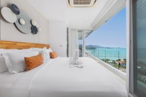 a bedroom with a large white bed with a view of the ocean at UniQue BoutiQue Resort in Bangrak Beach +126 photos