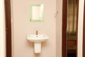 a bathroom with a sink and a mirror on the wall at Fine Homes in Kalpetta