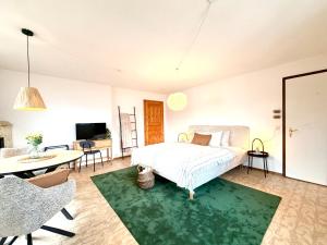 a bedroom with a bed and a living room at Studio Lake View Faulensee in Faulensee