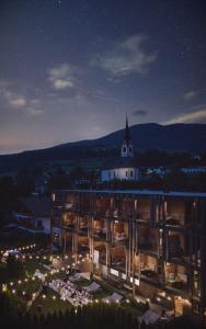 un grande edificio di notte con una chiesa di Hotel Christof a Monguelfo