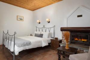 a bedroom with a bed and a fireplace at Archontiko Papoutsi Pelion in Mouresi