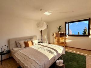 a bedroom with a bed and a large window at Studio Lake View Faulensee in Faulensee